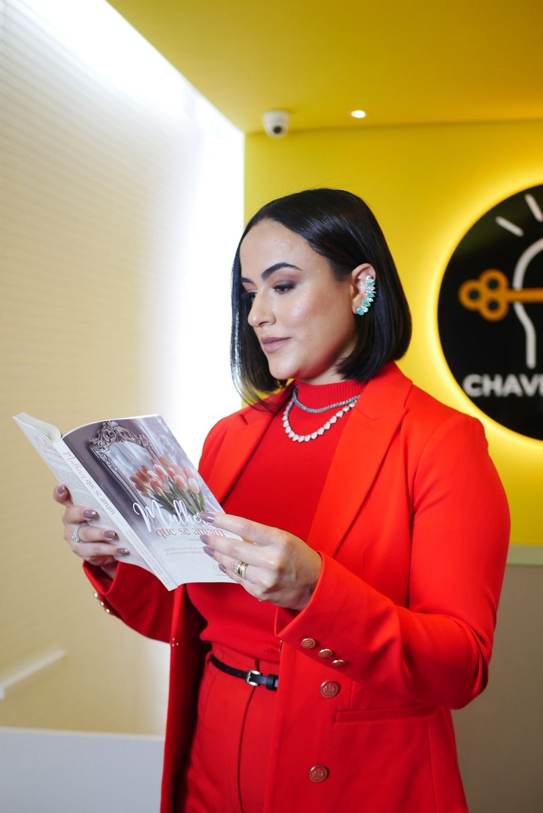 Camila Meneses segurando o livro Mulheres que se amam